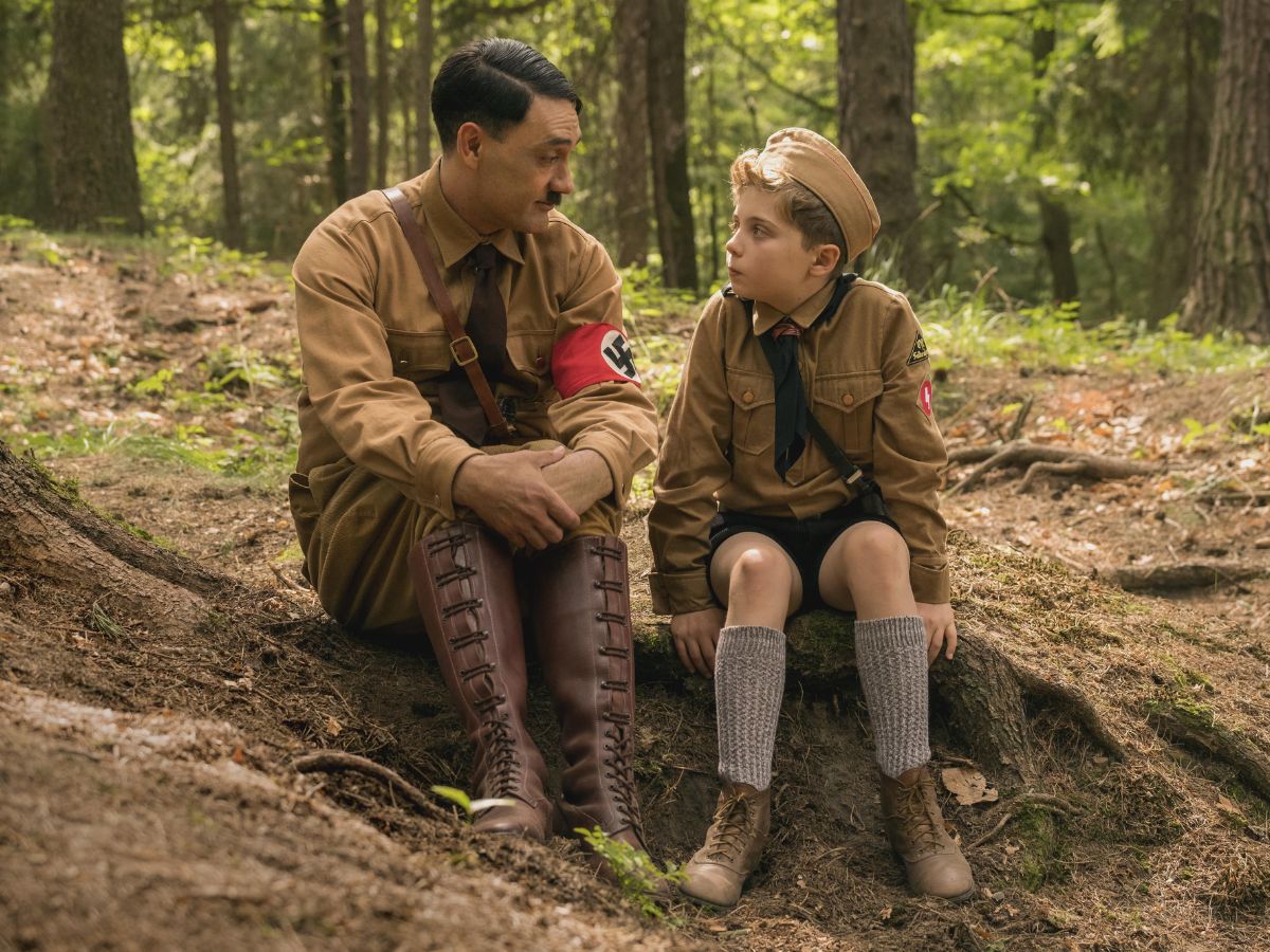 Escena de la película Jojo Rabbit en la que se ve a Hitler hablando con un niño en mitad de un bosque