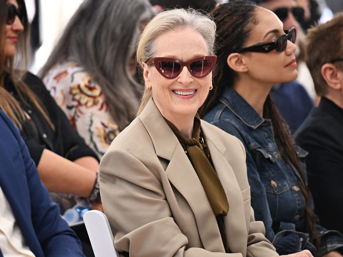 Meryl Streep sonríe con gafas de sol y blazer beige entre el público de un acto en Hollywood