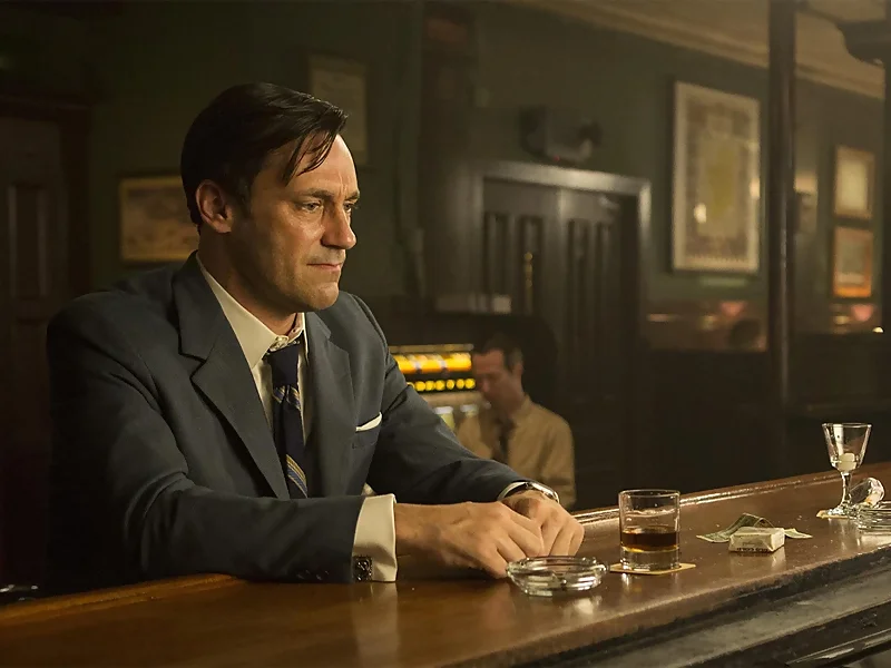 Don Draper, incapaz de disfrutar de sus logros, triste en un bar