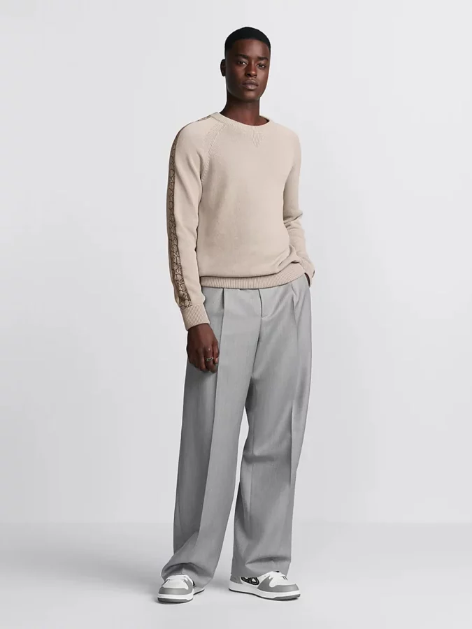 conjunto de Dior Men con suéter beige y pantalones anchos de pinzas grises