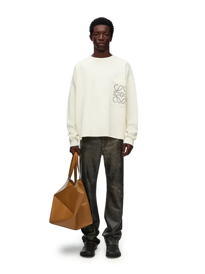 look de Loewe para hombres con suéter beige y pantalones de cuero de estilo desgastado