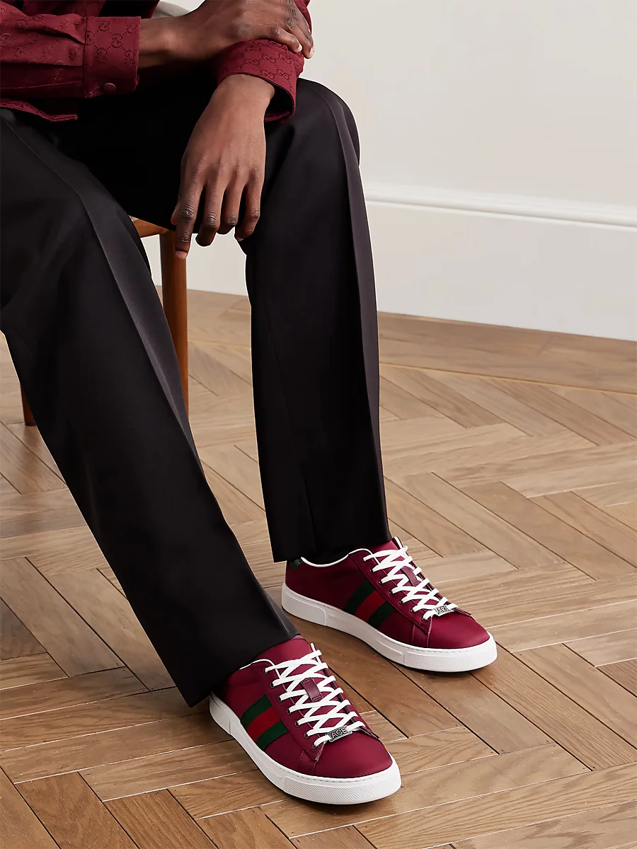 Pantalones negros de pinzas con zapatillas rojas de Gucci