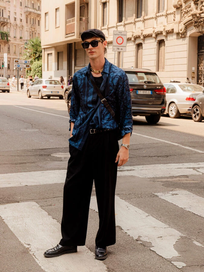 El modelo Kit Butler vestido con un pantalón negro y combinado con una camiseta negra y una camisa estampada