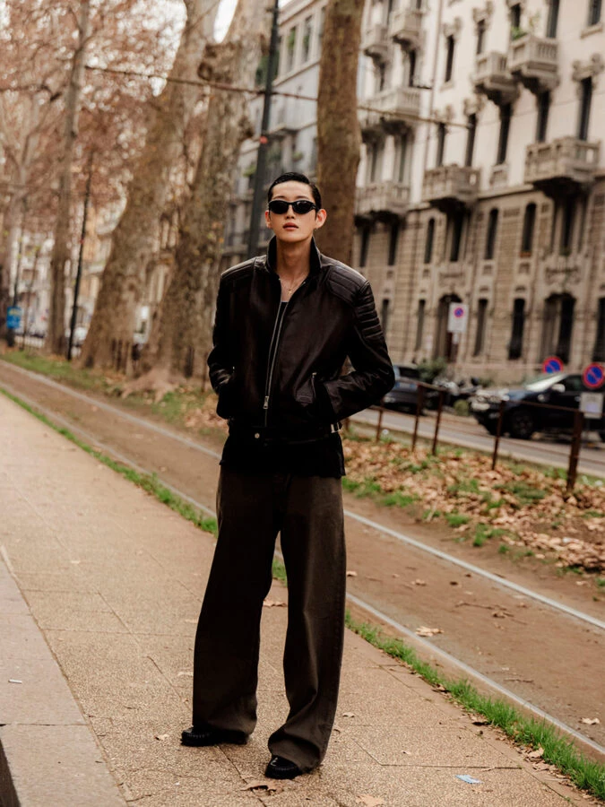 modelo con un pantalón negro combinado con una camiseta negra, una chaqueta de cuero y mocasines