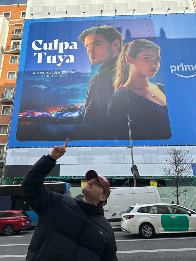 Gabriel Guevara delante del cartel de la promo de Culpa Tuya en Gran Vía