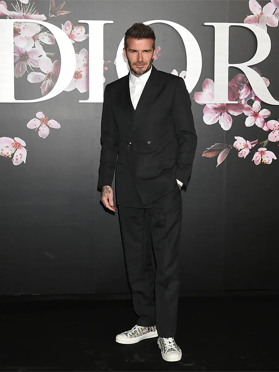 David Beckham con traje negro de doble botonadura y corte holgado y zapatillas de Dior