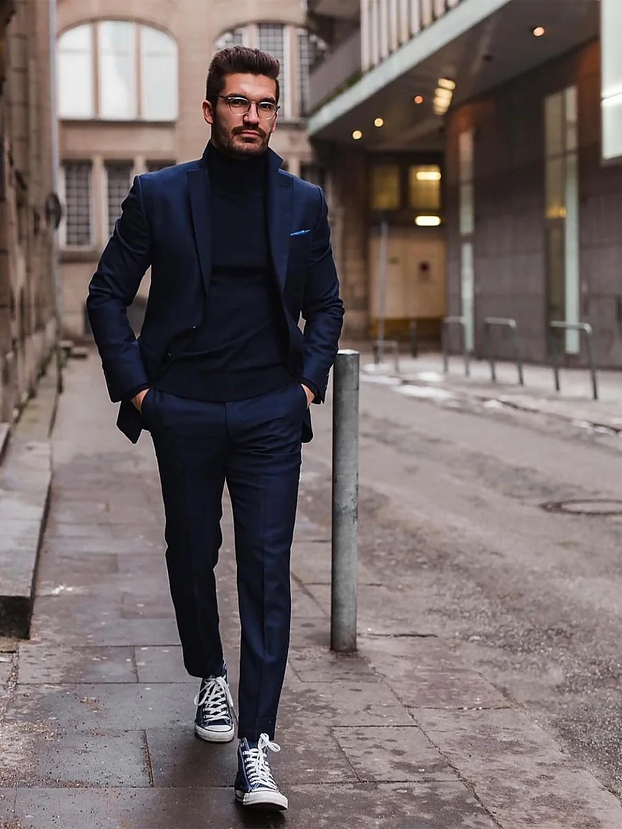 Justus F. Hansen con traje azul marino de invierno y Converse altas