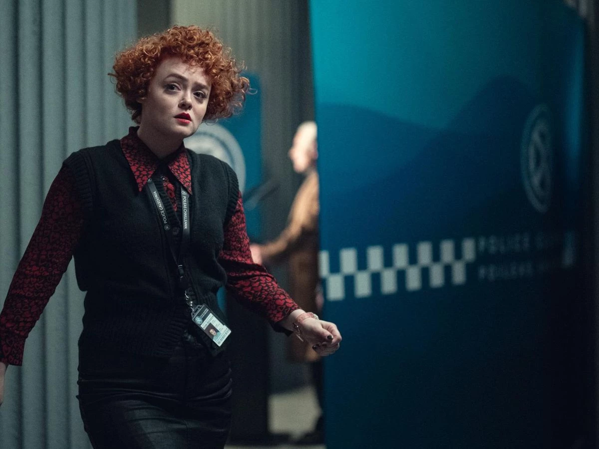 Escena de la serie Dept. Q con Helena Bonham Carter interpretando a una agente policial pelirroja en la comisaría