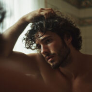 ¿Estamos cerca de la cura definitiva para la calvicie? hombre peinándose con la mano frente al espejo