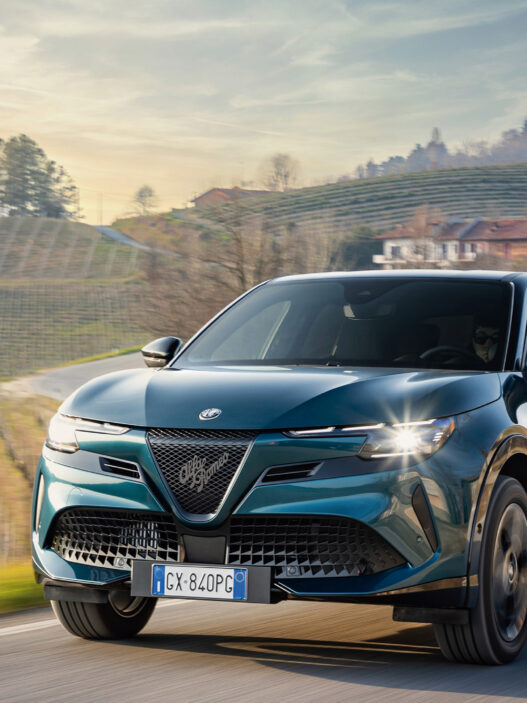 Vista frontal del Alfa Romeo Junior Ibrida Q4 2025 circulando por carretera de montaña.