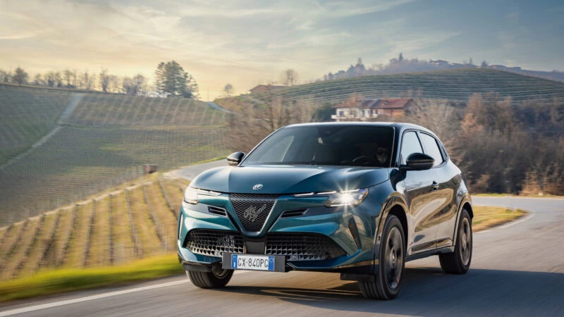Vista frontal del Alfa Romeo Junior Ibrida Q4 2025 circulando por carretera de montaña.