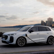 Audi Q3 e-hybrid 2025 cargando en un punto eléctrico frente al mar al atardecer