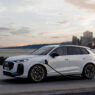 Audi Q3 e-hybrid 2025 cargando en un punto eléctrico frente al mar al atardecer