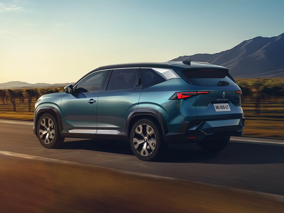 Vista trasera del Renault Boreal 2025 circulando por carretera al atardecer.