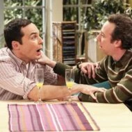 Stuart y Sheldon Cooper conversando en el salón, escena divertida de The Big Bang Theory.