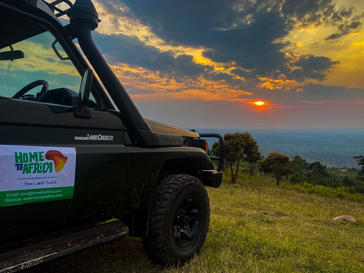 Vehículo de safari de Home To Africa en un parque nacional de Uganda al anochecer.