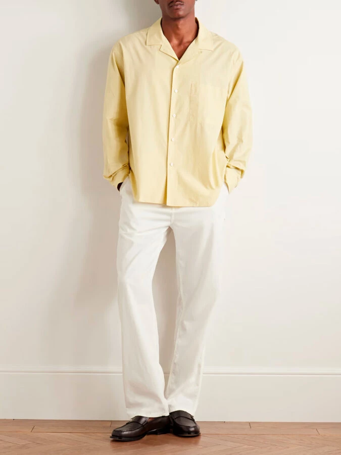 Look THE ROW para combinar pantalón blanco con camisa amarilla pastel y mocasines negros