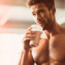 hombre de 40 años muy fuerte tomándose un batido de proteínas en un gimnasio