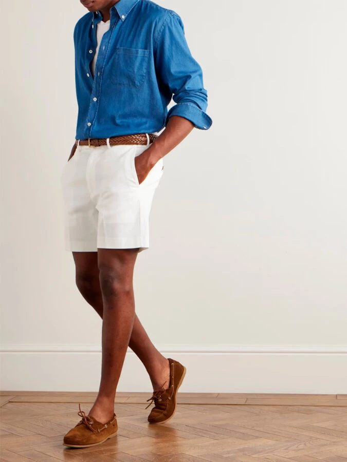 Look náutico moderno con bermudas blancas, camisa vaquera azul y náuticos de ante marrón de Tom Ford