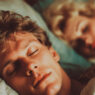 pareja de hombre y mujer durmiendo en una cama soñando