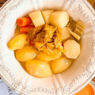 Plato de cocido tradicional con verduras del restaurante La Taberna de Mike Palmer.