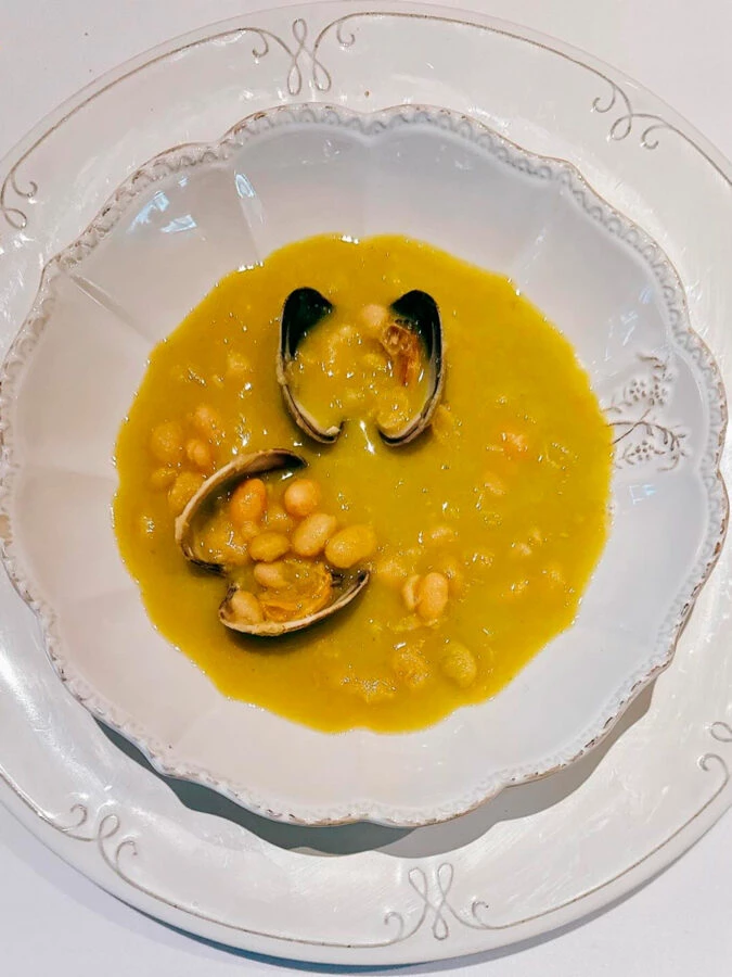 Guiso de legumbres con almejas del restaurante La Taberna de Mike Palmer.