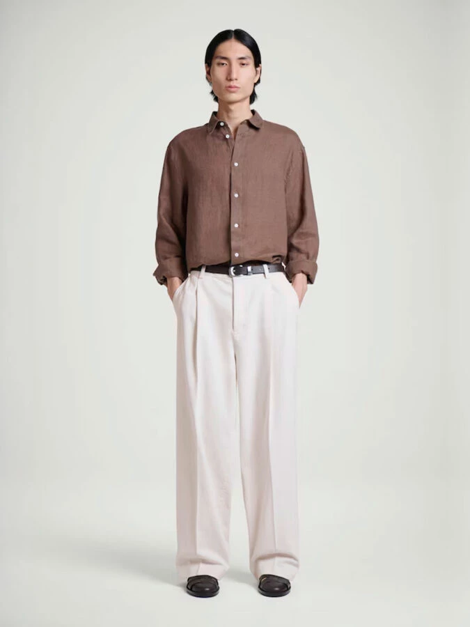 Hombre con pantalones anchos de algodón y lino de COS para cena informal de verano.
