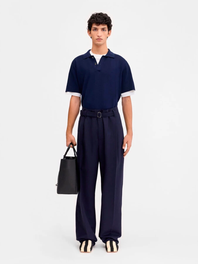 Outfit azul marino de Jacquemus con polo amplio y pantalón de pinzas para cena informal