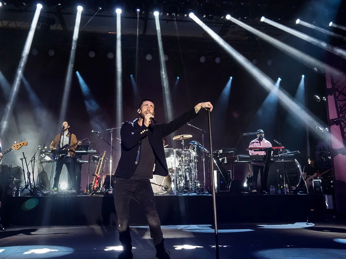 Adam Levine cantando en un concierto de Maroon 5 con la banda al completo