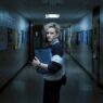 Secuencia de la película Weapons en la que se ve a Julia Garner (Justine) mirando hacia atrás en un pasillo del colegio