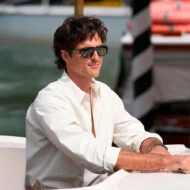 Jacob Elordi con camisa blanca y gafas de sol durante su llegada en góndola al Festival de Cine de Venecia 2025.