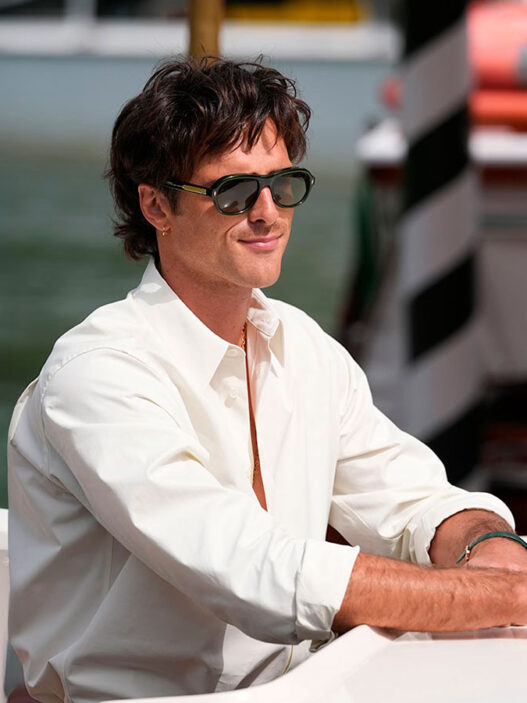 Jacob Elordi con camisa blanca y gafas de sol durante su llegada en góndola al Festival de Cine de Venecia 2025.