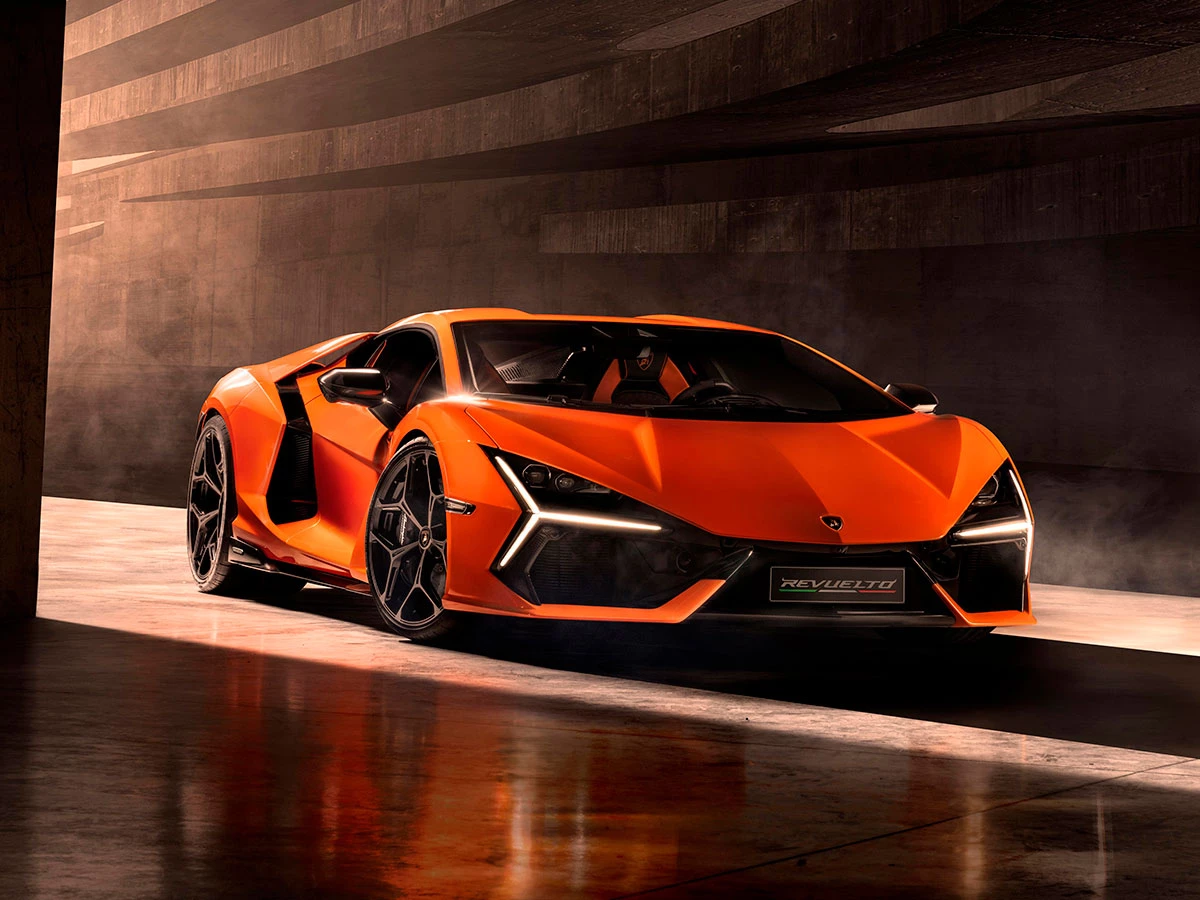 Lamborghini Revuelto en color naranja estacionado en un entorno industrial.