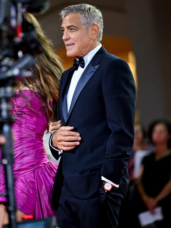 George Clooney con esmoquin en la alfombra roja de Venecia llevando reloj Seamaster 37 mm Milano Cortina 2026 de oro