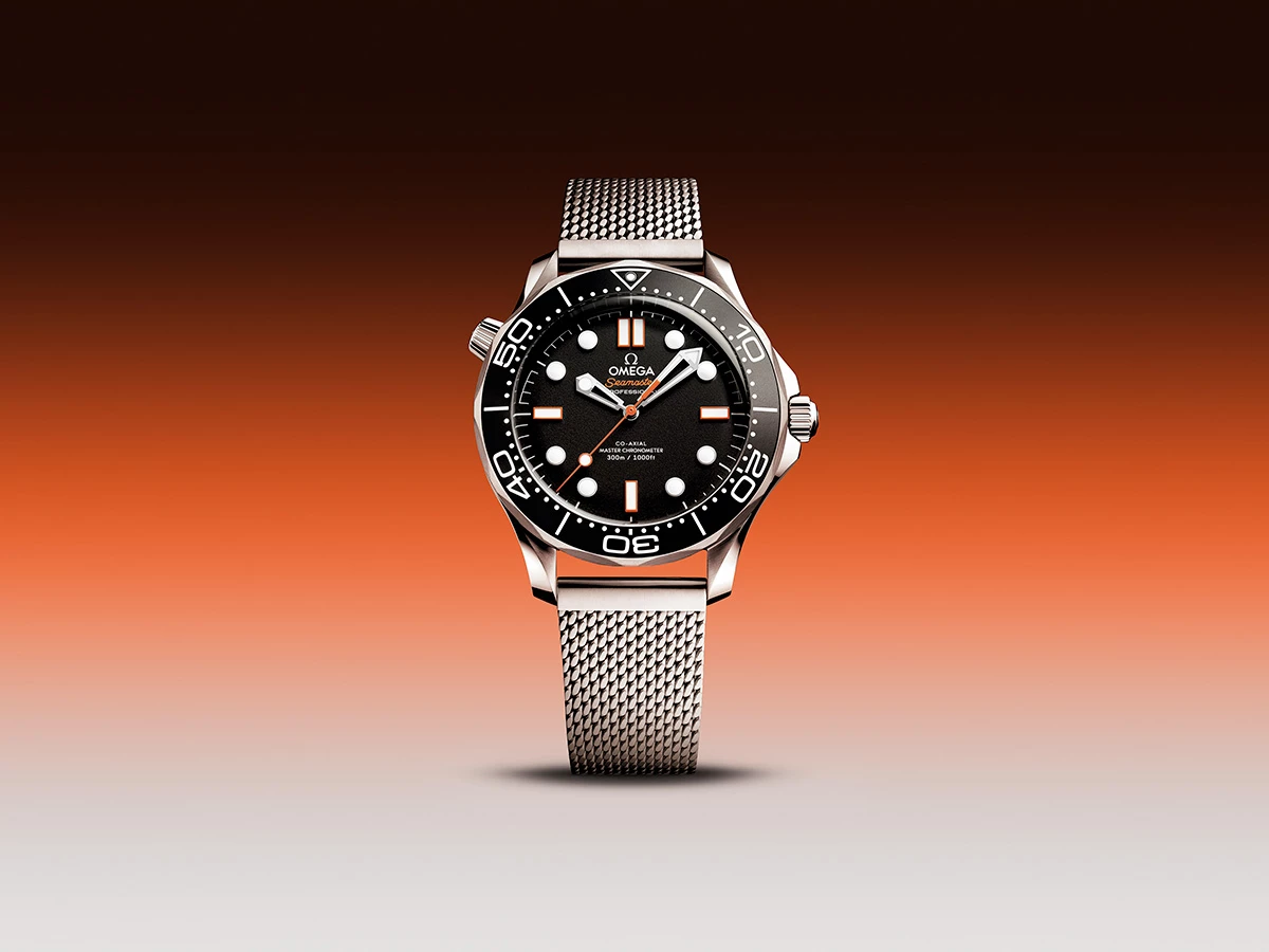  Reloj OMEGA Seamaster Diver 300M con brazalete de malla de acero y detalles en naranja.