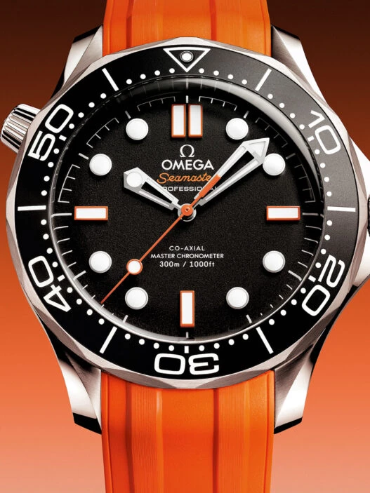 Reloj OMEGA Seamaster Diver 300M con correa de caucho naranja y esfera negra con detalles en naranja.