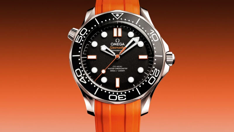 Reloj OMEGA Seamaster Diver 300M con correa de caucho naranja y esfera negra con detalles en naranja.