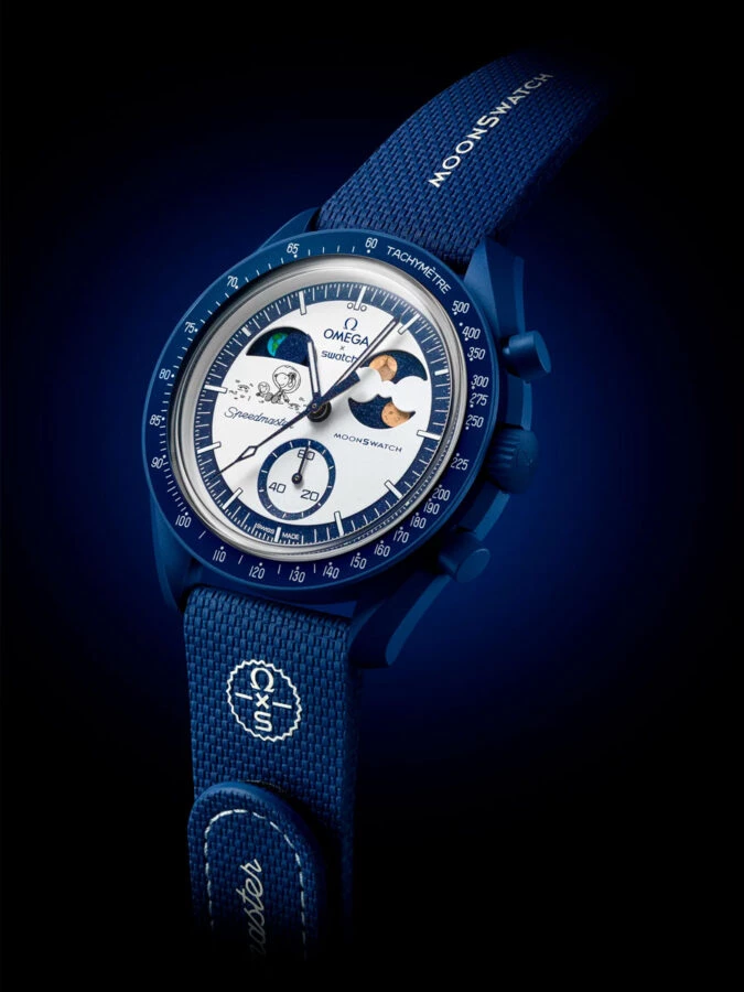 Vista frontal del reloj MoonSwatch EarthPhase Moonshine Gold con correa azul y caja Bioceramic.