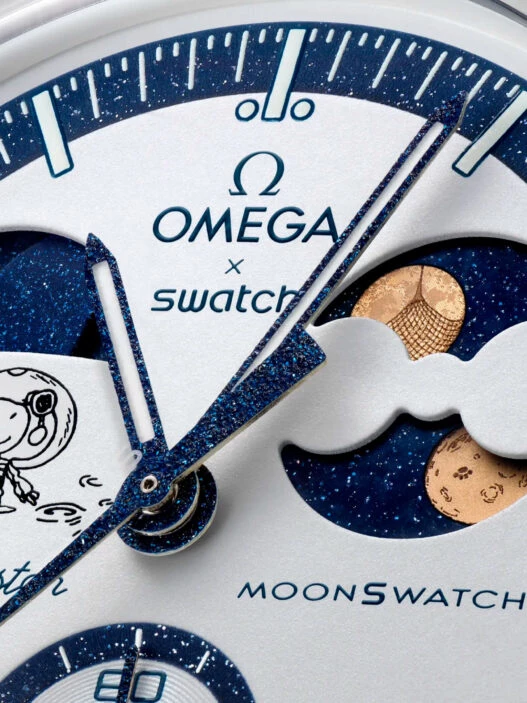 Detalle de la esfera del MoonSwatch EarthPhase Moonshine Gold con Snoopy, fases lunares y terrestres.