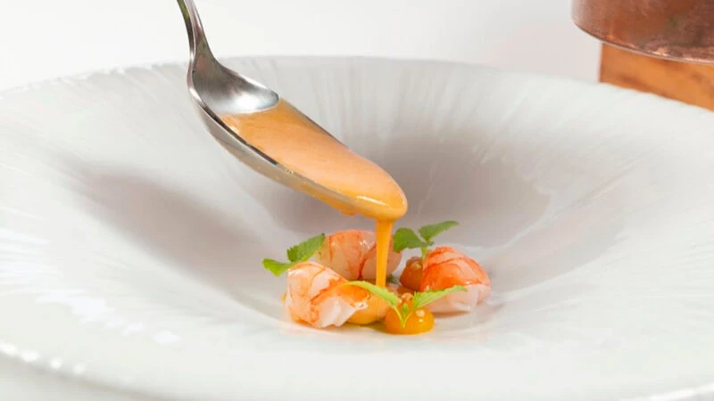Salseado de gamba roja fresca con crema tibia sobre colas peladas en el restaurante Marc Fosh.