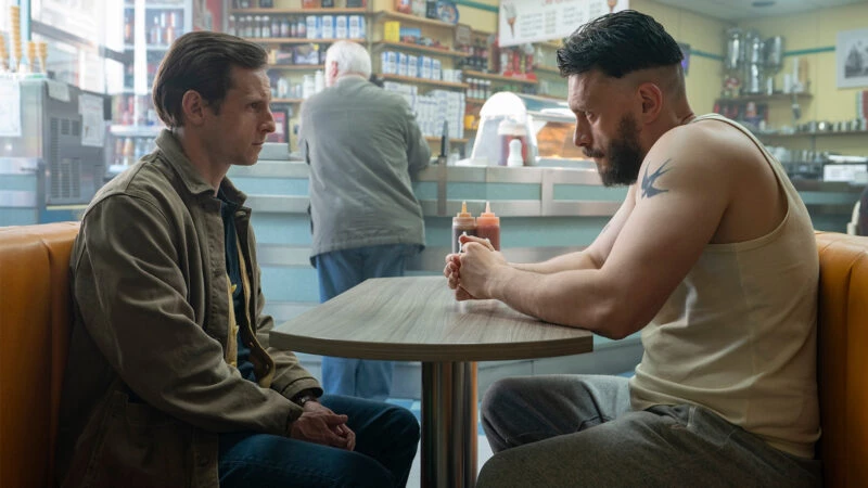 Protagonistas de la serie Half Man en una secuencia de la serie en la que aparecen sentados uno frente al otro en una cafetería