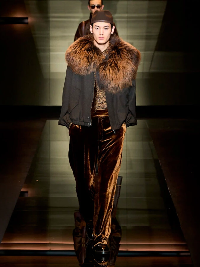 Modelo con abrigo de cuello de pelo y pantalones de terciopelo en el desfile de Emporio Armani otoño-invierno 2025/2026