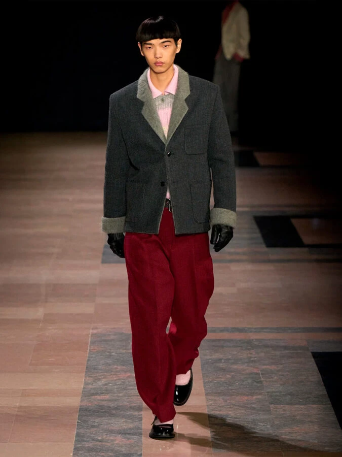 Modelo con pantalones burdeos amplios y blazer gris de Kenzo otoño-invierno 2025/2026