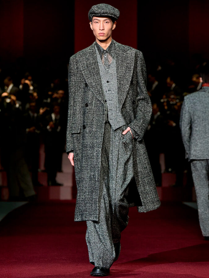 Modelo con traje tres piezas de tweed gris y abrigo largo en el desfile Dolce & Gabbana otoño invierno 2025.