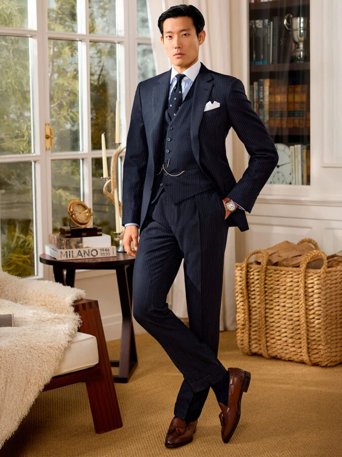 Traje tres piezas de raya diplomática azul marino con chaleco y leontina de Ralph Lauren colección otoño invierno 2025.