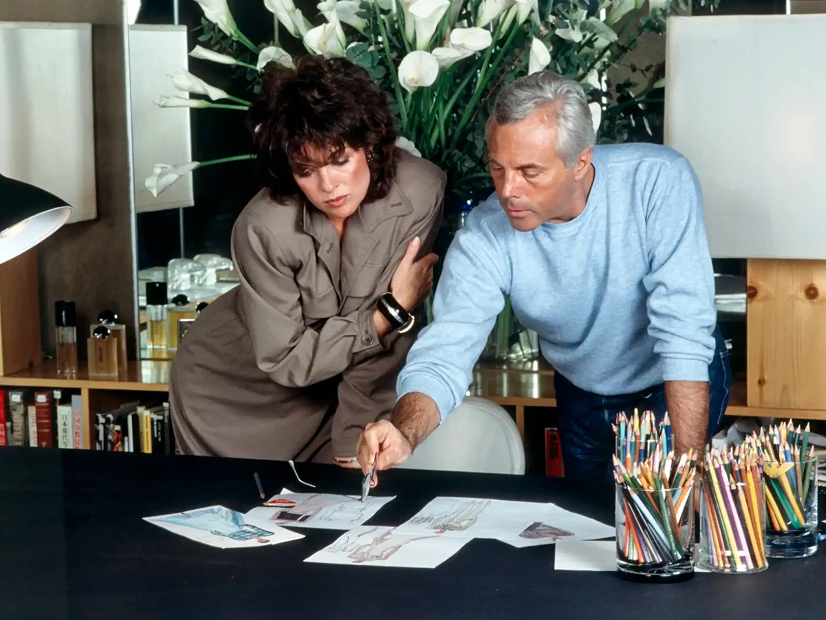 Armani mostrando algunos bocetos a la actriz estadounidense Linda Gray en 1983.
