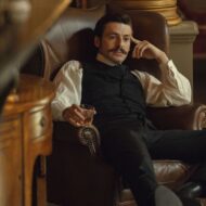 Escena de la serie La casa Guinness de Netflix en la que aparece el protagonista sentado en un sillón