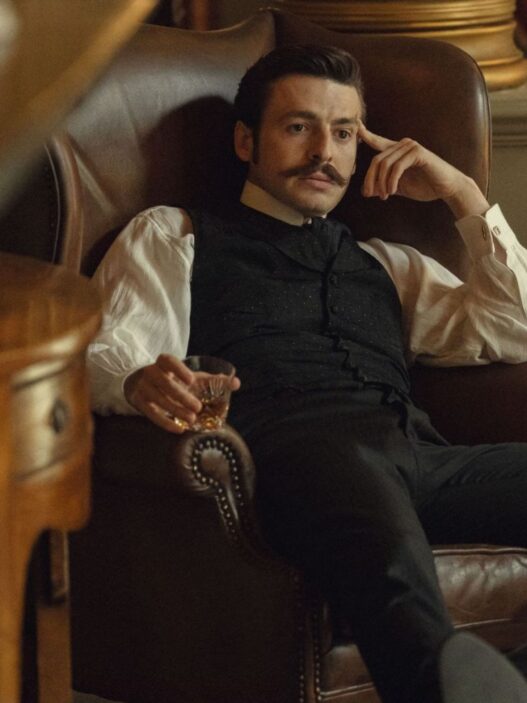 Escena de la serie La casa Guinness de Netflix en la que aparece el protagonista sentado en un sillón