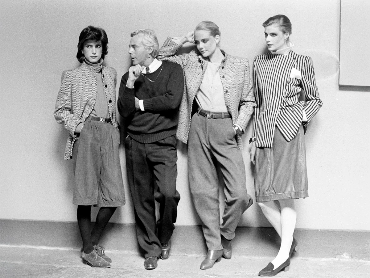 Armani posando para un retrato con modelos en un avance de la colección prêt-à-porter otoño-invierno 1980.