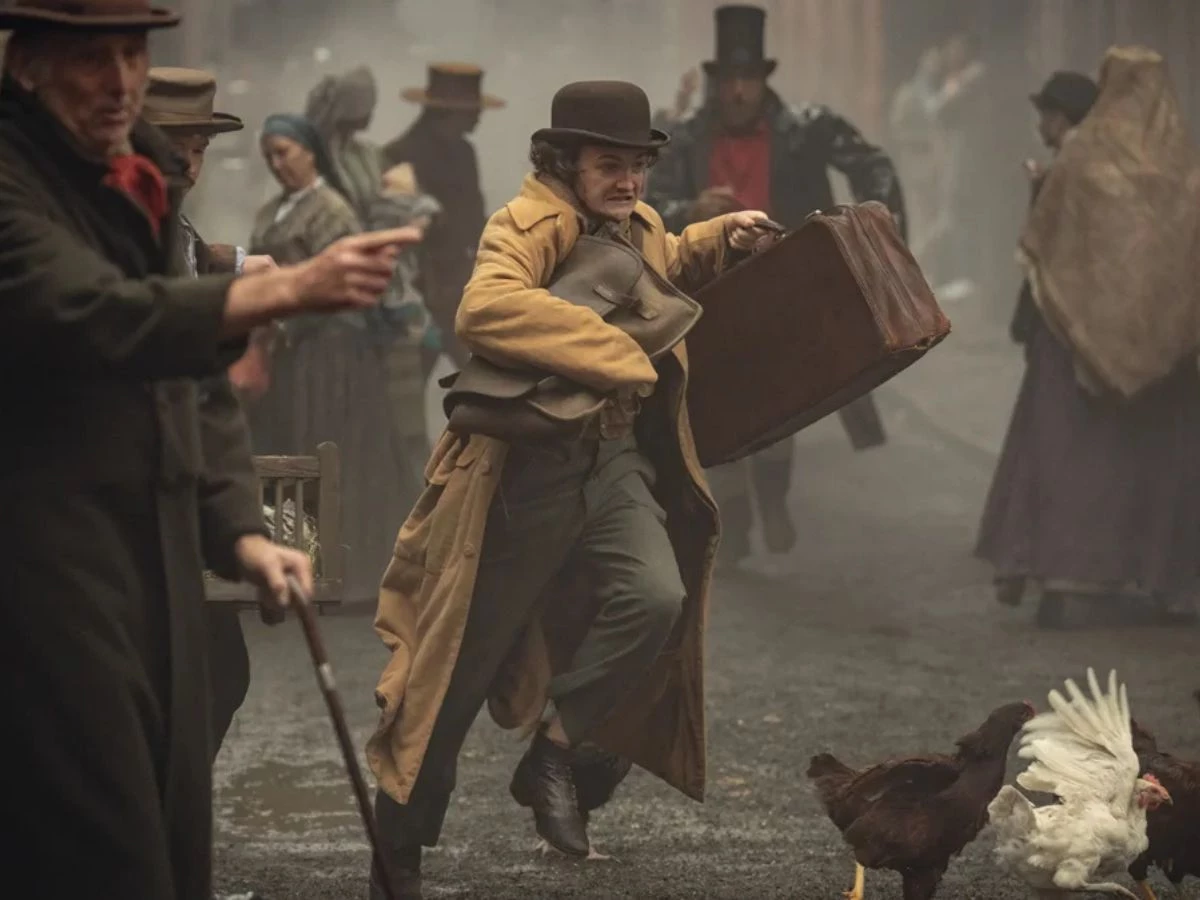 Escena de la serie La casa Guinness de Netflix en la que aparece una mujer corriendo en mitad de la calle con una maleta en la mano